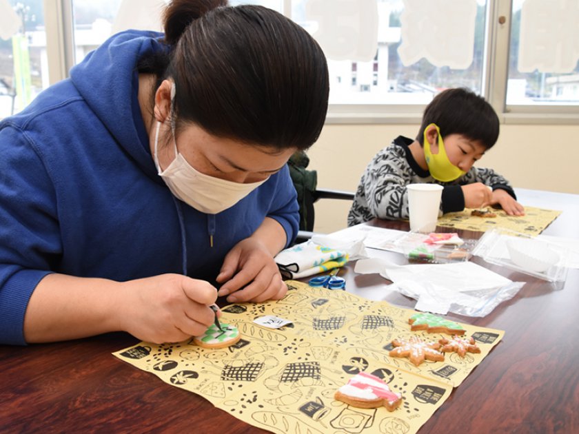 クッキーの上に模様を描くようすの親子