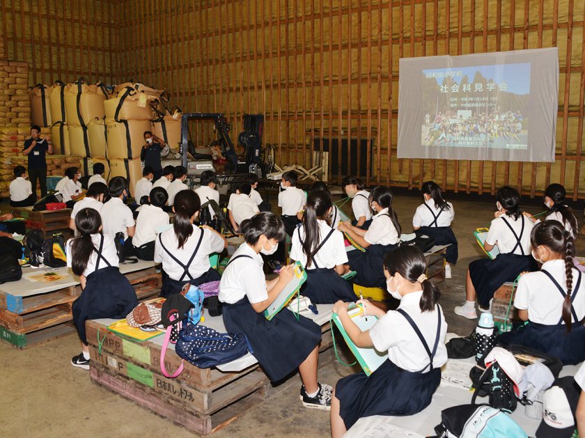 米低温倉庫内に用意した「特設ライスシアター」で福井県の農業を学ぶ児童
