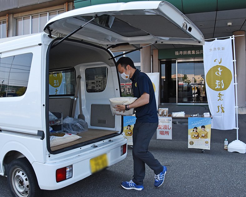 JA福井基幹支店前で開かれたドライブスルー販売会で、いちほまれを車に積み込む係員のようす