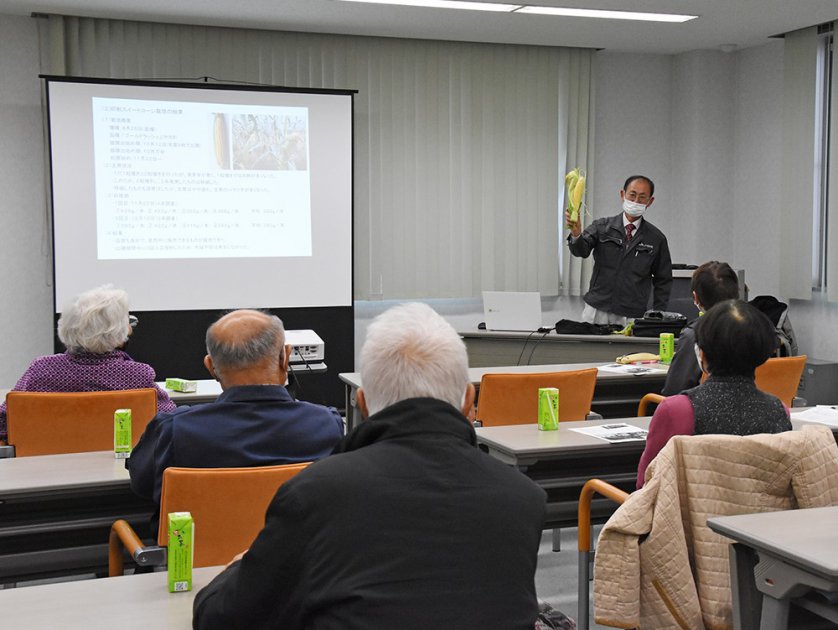 8月に播種して栽培した抑制スイートコーンについて説明する嶋田顧問㊨