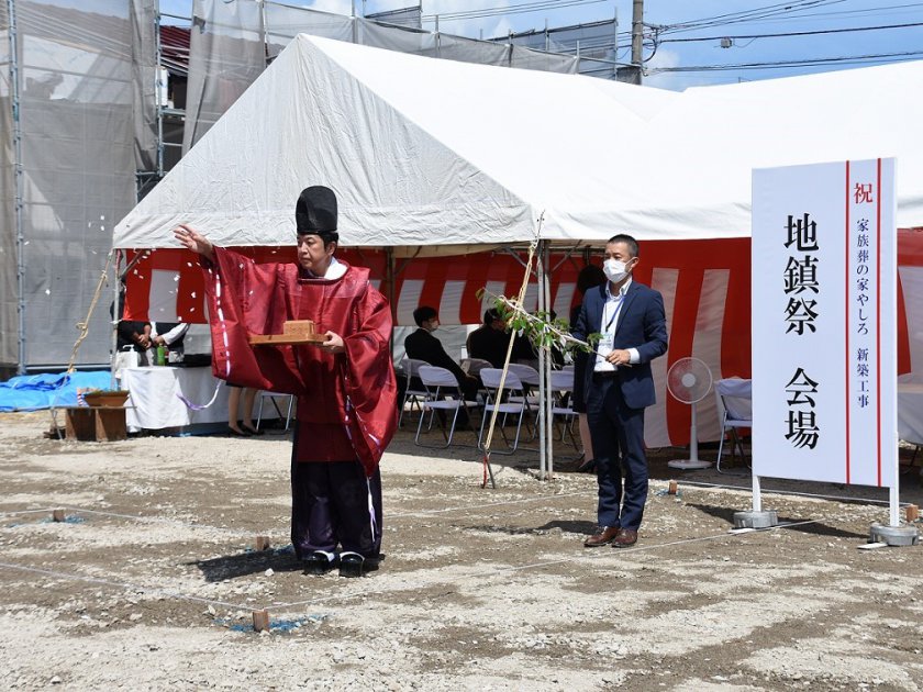 清祓いの儀で神主が建物四方を清めているようす