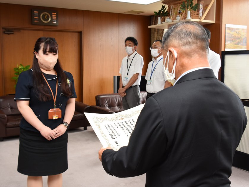 表彰される酒井係長㊧