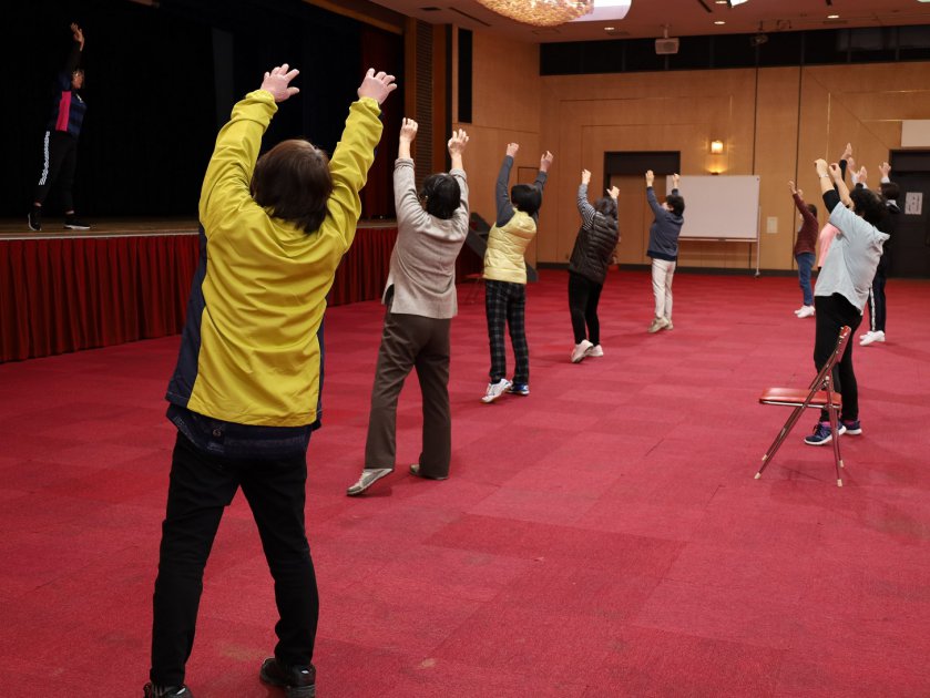 ひとつひとつの動きを確認しながらラジオ体操を行う参加者